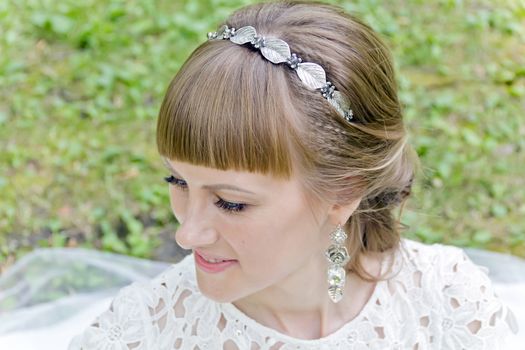 Portrait of beautiful smiling bride with diadem in the summer park