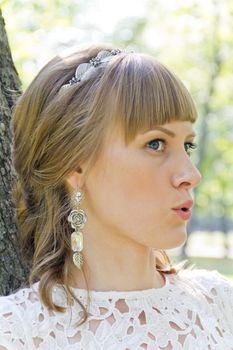 Beautiful portrait of talking bride with diadem in summer background