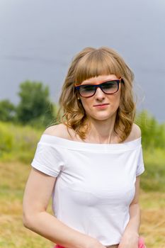 Portrait of thinking girl in sunglasses on river background