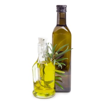 Two different glass bottles of the olive oil and olive branch on a white background
