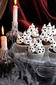 Chocolate muffin meringues with meringues on the table in honor of Halloween
