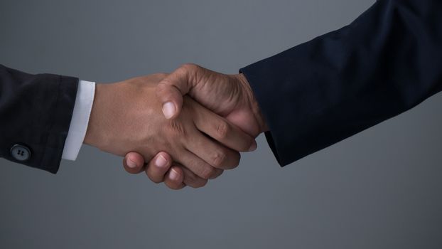 Image businessman handshake , Hand holding on gray background