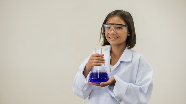 Asian little girl holding test tube or laboratory flask . Education concept.