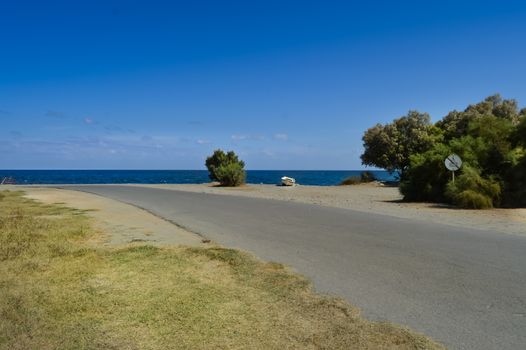 Road to the pebble beach of Maleme with a boat abandon in the north west of the island of Crete in Greece