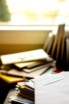 Meeting Tomorrow; Stack of Documents. Working or Studying at messy desk.