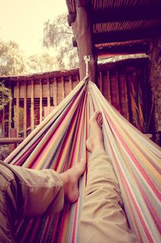 Man relaxing in a colored hammock. subjective view