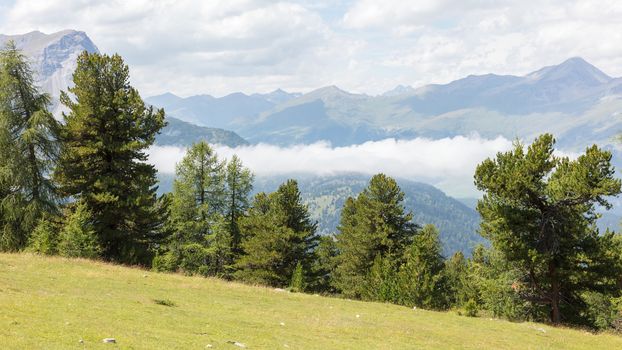 View of beautiful landscape in the Alps - Clouds rolling past the mountains