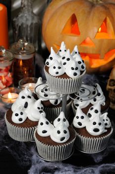 Chocolate muffin   with ghost  meringues on the table in honor of Halloween
