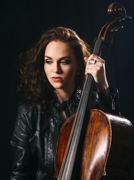 Photo of a beautiful woman holding her old cello.
