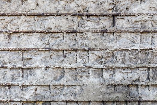 Fragment of a gray concrete wall with metal structures,background