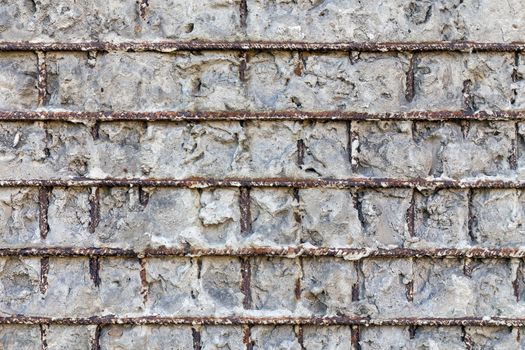 Fragment of a gray concrete wall with metal structures,background