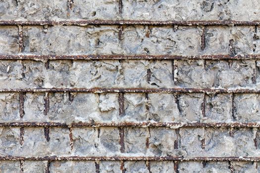 Fragment of a gray concrete wall with metal structures,background