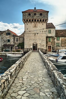 A stone, historic castle and bridge in the town of Kastel in Croatia
