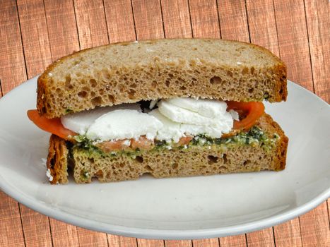 Sandwich with goat cheese, tomatoes, onion and seasoning with olive oil