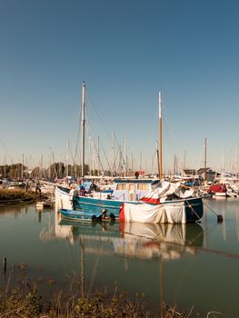 parked private boat in front of harbour marina scene masts; essex; england; UK