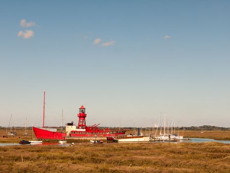 red life boat moored in tollesbury maldon estuary blue sky; essex; england; UK