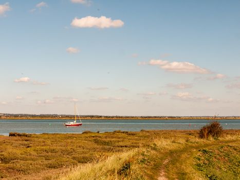 beautiful scene of river with boats grassland in front blue sky and clouds; essex; england; UK