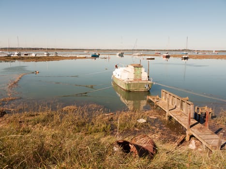 parked boat in estuary with wooden walkway to; essex; england; UK