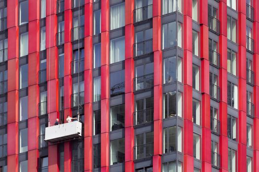Red tower window cleaners in a gondola in Rotterdam in the Netherlands 