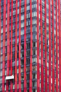 Red tower window cleaners in a gondola in Rotterdam in the Netherlands 