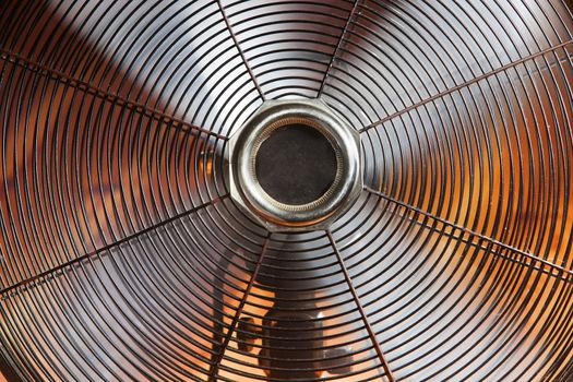 Close-up of a vintage spinning ventilator with a warm orange background