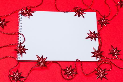 Holiday decorations and notebook on red background