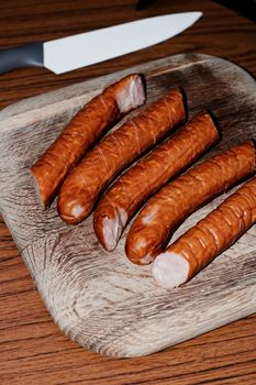 Fresh and tasty sausages on the wooden board. BBQ concept.