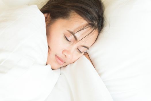 Closeup young woman sleeping with happy face in the bed, copy space