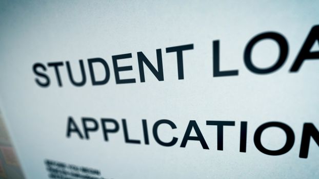 Unexpected 3d illustration of a student loan application presented askew in the white background on a computer screen. The title is printed in big font capital letters.