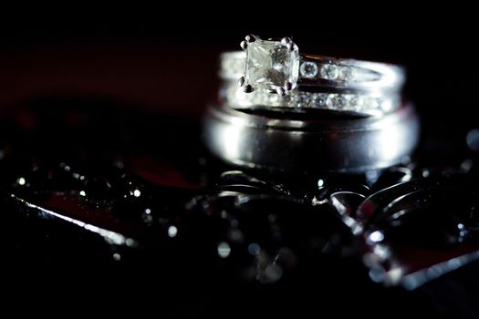 Beautiful diamond wedding rings in a black textured background.