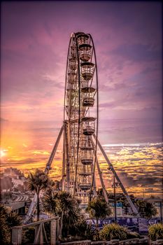 A big ferris wheel on the seafront at Bournemouth with a sunset in upright format