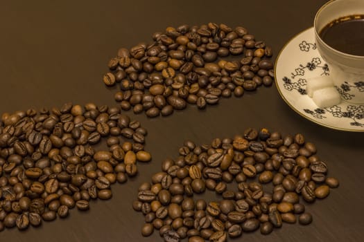 A cup of coffee and coffee beans on the table.