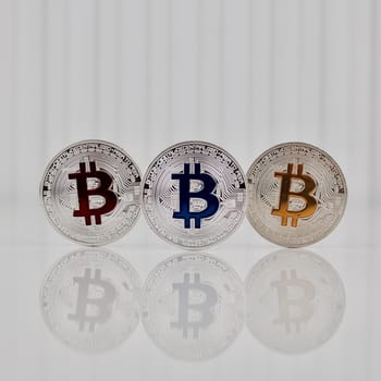 Digital currency physical silver colorful bitcoin coins on white scene.
