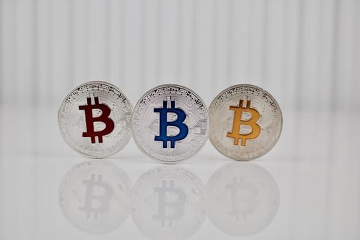 Digital currency physical silver colorful bitcoin coins on white table.