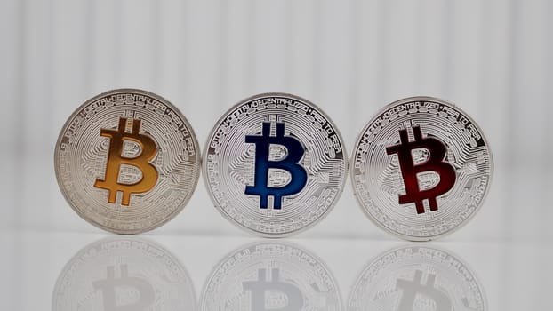 Digital currency physical silver bitcoin coin on the table. Colorful concept.