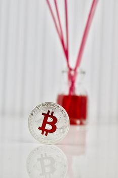 Digital currency physical silver bitcoin coin in red background.