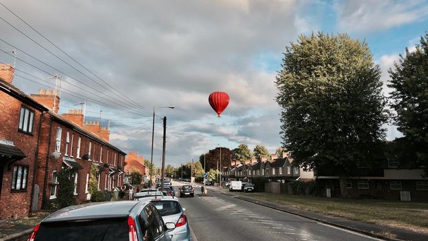 Big red balloon over the road near green tree in Newport Pagnell. Bedfordshire. England.