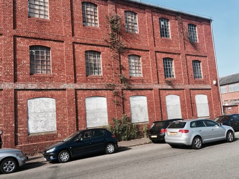 Cars near old brick warehouse with wooden in windows. Newport Pagnell