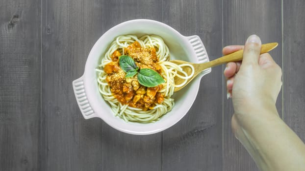 Plate of delicious spaghetti bolognese with savory minced beef and tomato sauce garnished with  basil, overhead view