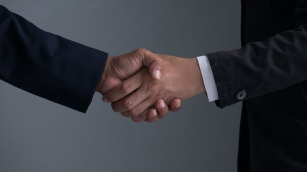 Image businessman handshake , Hand holding on gray background