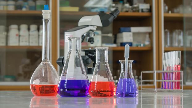 Different laboratory test tubes with colored liquid and with reflection