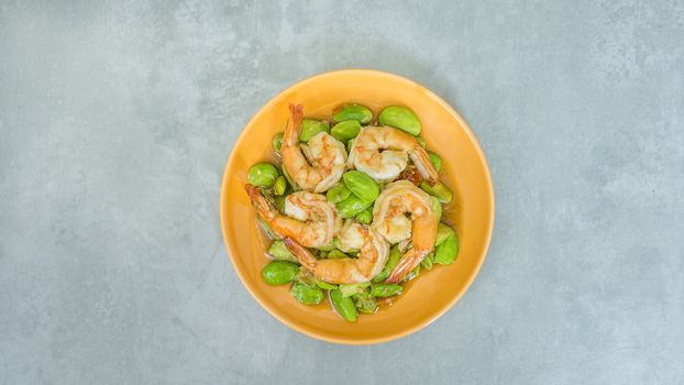 top view of Stir-Fried Twisted Cluster Bean with Shrimps/Butter Bean on orange dish