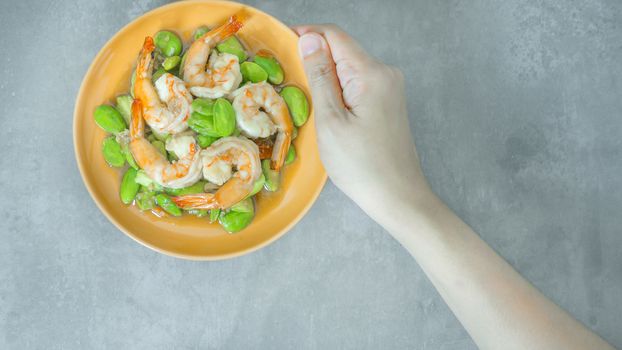 top view of Stir-Fried Twisted Cluster Bean with Shrimps/Butter Bean on orange dish