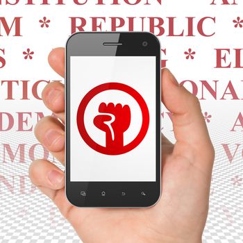 Political concept: Hand Holding Smartphone with  red Uprising icon on display,  Tag Cloud background, 3D rendering