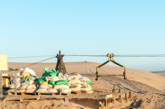 A cableway pylon and trolley at the guano island near Longbeach in the Namib Desert on the Atlantic Coast of Namibia