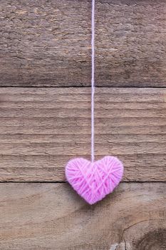 heart shape made from knitting wool on old shabby wooden background, Image of Valentine's day