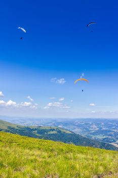 Three persones skydiving  flying over the mountains. parachute extreme sport