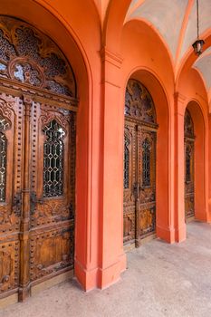 arch enter to old red synagogue with wooden doors
