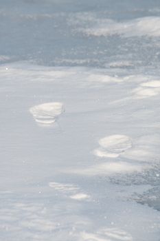 footprints in the snow on frozen lake in winter