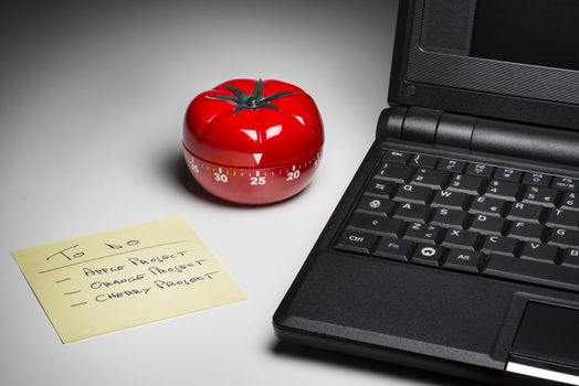 Tomato-shaped kitchen timer set at 25 minutes to fight procrastination in studying and working.
